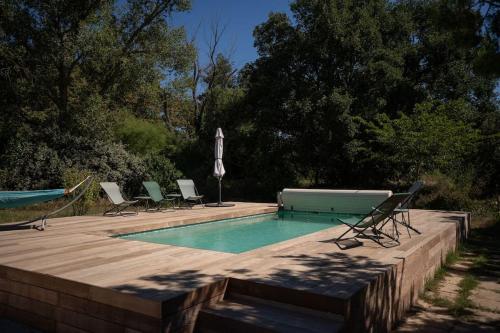 une piscine avec des chaises longues et une table dans l'établissement Agréable Maison Contemporaine en Provence, à La Mérindolle