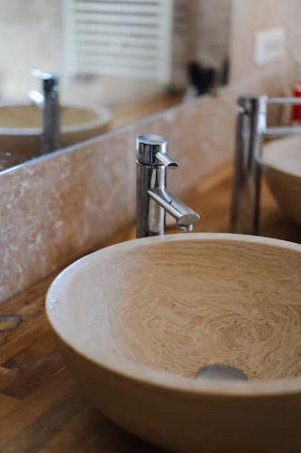 La salle de bains est pourvue d'un lavabo avec un robinet en argent. dans l'établissement Agréable Maison Contemporaine en Provence, à La Mérindolle