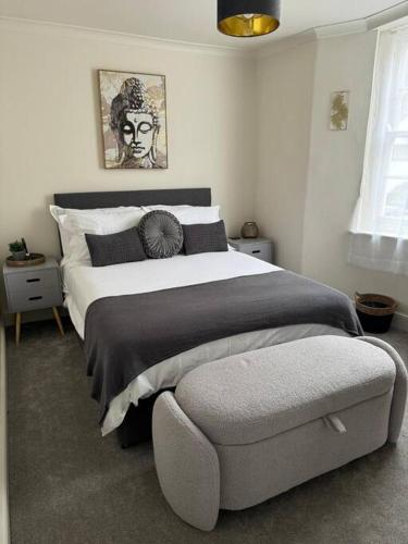 a bedroom with a large bed and a chair at Townhouse in Weymouth, Dorset in Melcombe Regis