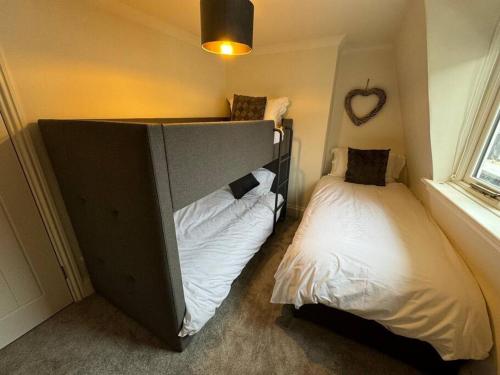a bedroom with two beds and a headboard and a bedskirts at Townhouse in Weymouth, Dorset in Melcombe Regis