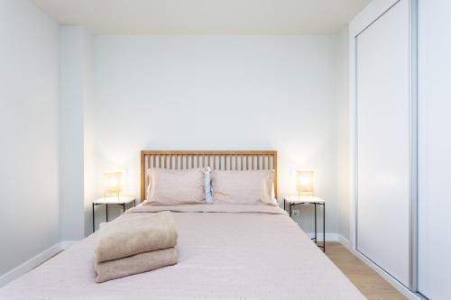 AbadesにあるHome2Book Orballo Sea Views Apt, Terrace&Poolの大きな白いベッドと2つのランプのある寝室