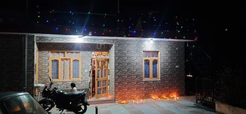 a brick house with a motorcycle parked in front of it at Sejal Homestay in Shimla