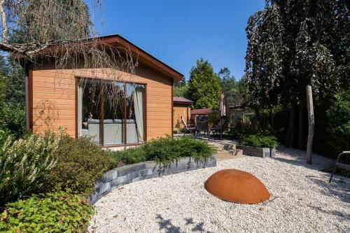 a home with a garden with a large orange object in the yard at Chalet omringd door groen op de Veluwe - Perfect voor gezinnen in Putten