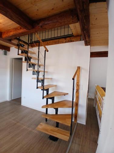 a spiral staircase in a room with wooden ceilings at Ferienwohnung Ornela in Eggolsheim