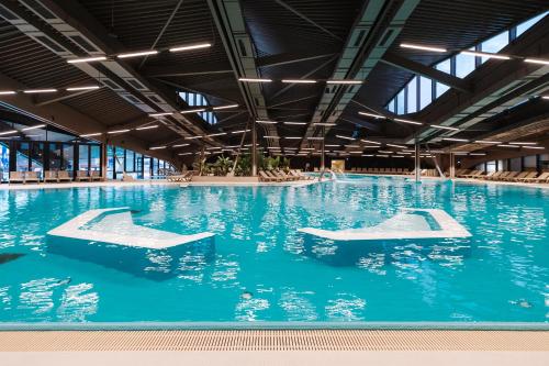 an indoor swimming pool with blue water at Terme Tuhelj Hotel Well in Tuheljske Toplice