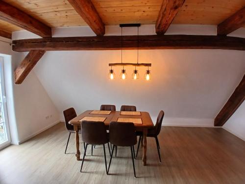 a dining room with a wooden table and chairs at Ferienwohnung Ornela in Eggolsheim