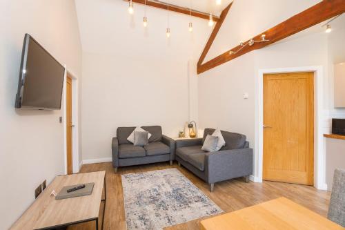 a living room with two couches and a flat screen tv at City Apartments - Monkbar Mews in York