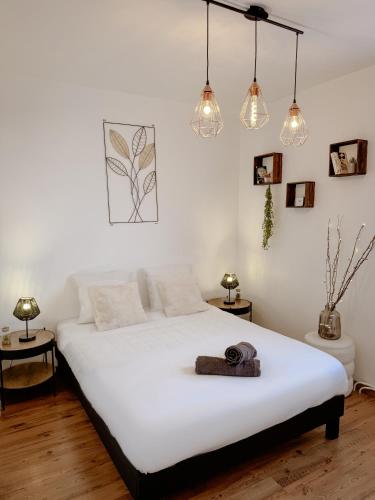 - une chambre avec un grand lit blanc et des lumières dans l'établissement Le Balcon des Marots - Proche centre-ville Troyes, à Troyes