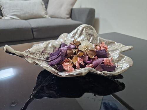 a bowl of flowers sitting on top of a table at Cozy flat & Lovely garden, High Speed WiFi in Cranford
