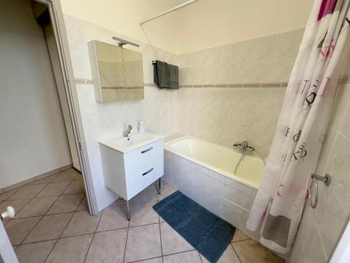 une salle de bain avec une baignoire, un lavabo et une douche dans l'établissement Soleil et Confort - Appartement Moderne à Nice, à Nice