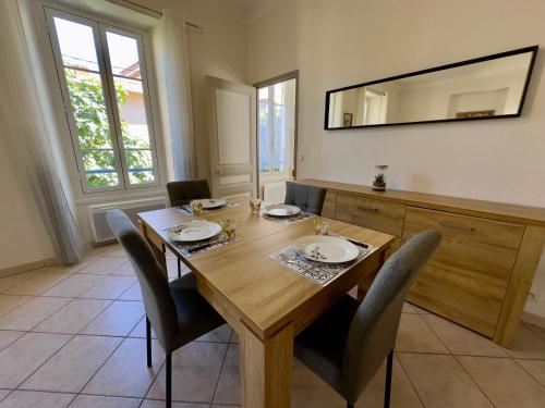 - une table à manger avec des chaises et un miroir dans l'établissement Soleil et Confort - Appartement Moderne à Nice, à Nice
