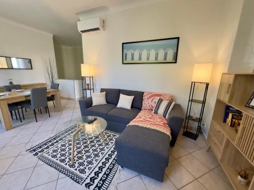 un salon avec un canapé bleu et une table dans l'établissement Soleil et Confort - Appartement Moderne à Nice, à Nice