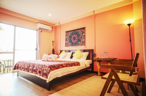 a bedroom with a bed and a table and a piano at Elegant Lanna Guesthouse in Chiang Mai