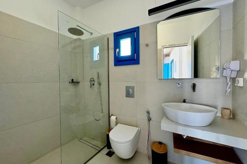 a bathroom with a sink and a toilet and a shower at Eleni On The Beach in Katapola