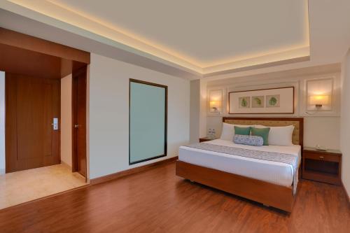a bedroom with a bed and a large window at Lemon Tree Resort, Mussoorie in Mussoorie