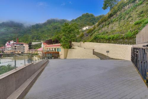 a bridge over a river with a mountain at Lemon Tree Resort, Mussoorie in Mussoorie