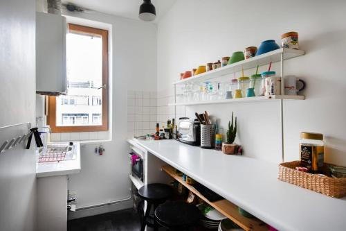 une cuisine blanche avec un comptoir et une fenêtre dans l'établissement Charming Studio near Le Marais and Bastille, à Paris