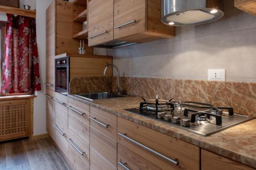 a kitchen with wooden cabinets and a stove top oven at ALLE ANTICHE MINIERE - CASA VACANZE in Zenich