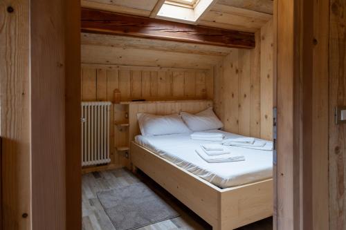 a bedroom with a bed in a wooden room at ALLE ANTICHE MINIERE - CASA VACANZE in Zenich