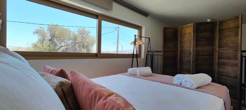 a bedroom with a large bed and a large window at LIVAS Residence in Tympáki