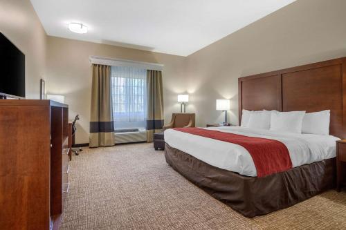 a hotel room with a large bed and a television at Comfort Inn & Suites Glenpool in Glenpool