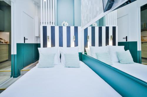 une chambre avec deux lits avec des oreillers blancs dans l'établissement WS Louvre - Casanova, à Paris