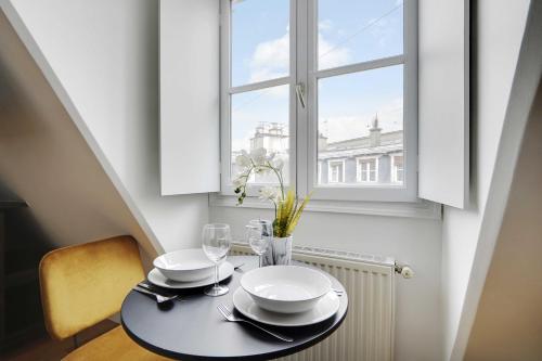une table avec des assiettes, des verres et une fenêtre dans l'établissement Magnificent studio - 2P - Arc de Triomphe, à Paris
