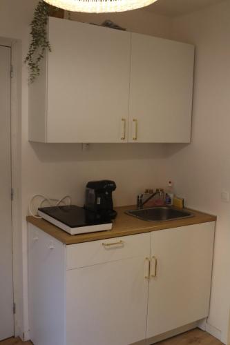 a kitchen with white cabinets and a sink at Appartement centre ville in Arras
