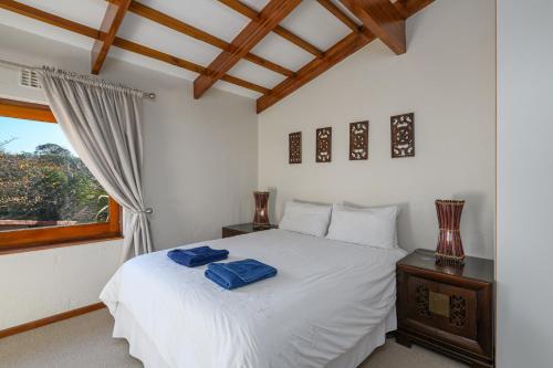 a bedroom with a white bed and a window at San Lameer Villa's in Southbroom