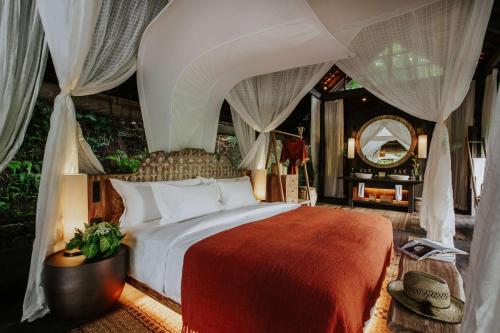 a bedroom with a bed with a canopy at Buahan, a Banyan Tree Escape in Payangan