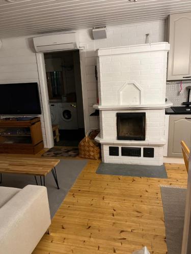 a living room with a white brick fireplace at Villa Porotupa in Syöte