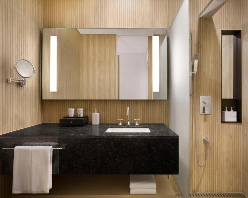 a bathroom with a sink and a mirror at Cassia Sokcho in Sokcho