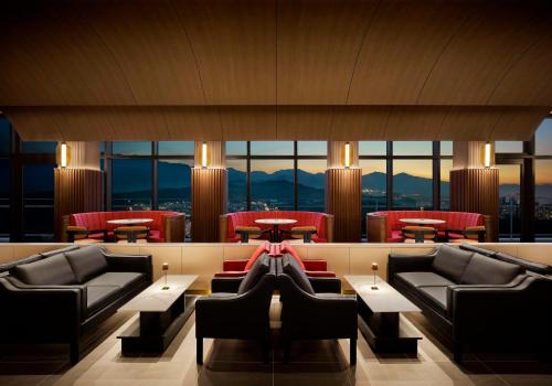 a hotel lobby with couches and tables and windows at Cassia Sokcho in Sokcho