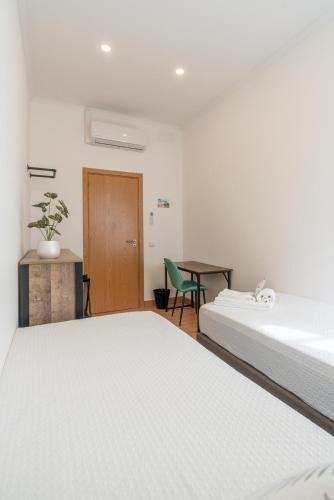 a bedroom with two beds and a table and a chair at Leevin Guesthouse in Faro