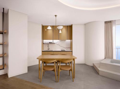 a kitchen and dining room with a wooden table and chairs at Cassia Sokcho in Sokcho
