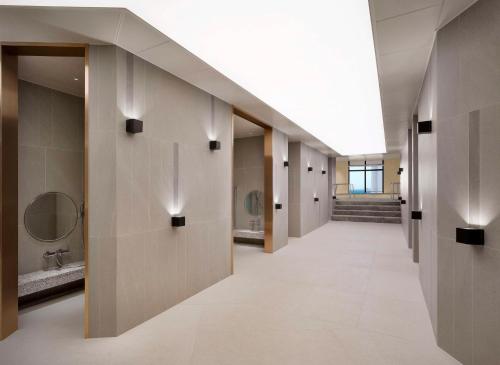 a hallway of a bathroom with sinks and mirrors at Cassia Sokcho in Sokcho