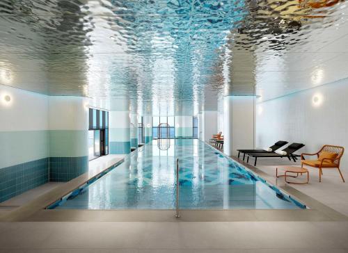 a pool in a building with a ceiling filled with water at Cassia Sokcho in Sokcho