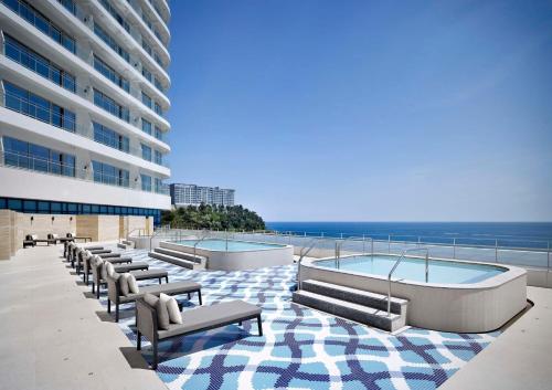 a building with a row of benches and a swimming pool at Cassia Sokcho in Sokcho