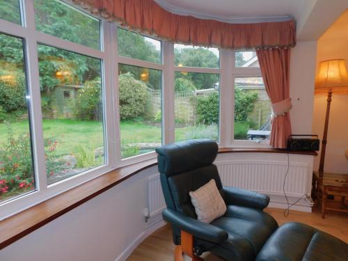 a living room with a chair and windows at 7 Links Way in West Runton