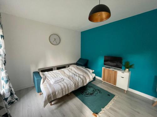 une chambre avec un lit et une horloge au mur dans l'établissement Maisonnette de Senlis, à Senlis