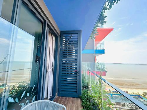 a balcony with a view of the beach and a building at Flamingo1 Ibiza Hai Tien in Nam Khê