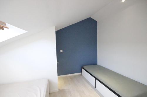 Cette chambre comprend un lit et un mur bleu. dans l'établissement ymmo 33123, au Le Verdon-sur-Mer