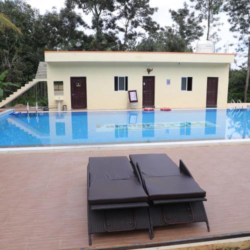 un resort con piscina e una casa di Chikku's Mercedes Stay @ Farmers Son Camping a Sakleshpur