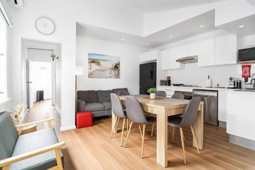 a kitchen and living room with a wooden table and chairs at Balmain Garden Hideaway with BBQ in Sydney