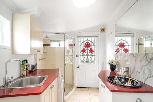 a kitchen with a sink and a red counter top at Balmain Garden Hideaway with BBQ in Sydney