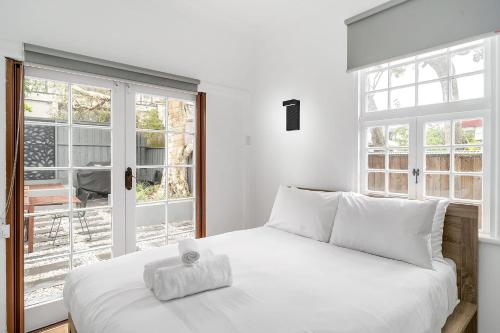 a bedroom with a white bed with a towel on it at Balmain Garden Hideaway with BBQ in Sydney