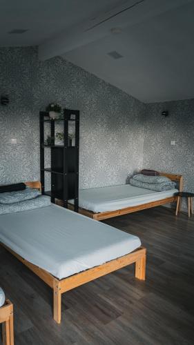 three beds in a room with a wall at ILSA camping in Bauska