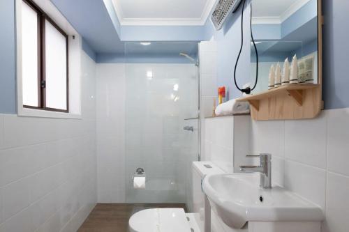 a white bathroom with a sink and a toilet at Erowal Bay Retreat Alfresco Dining Serenity in Worrowing Heights