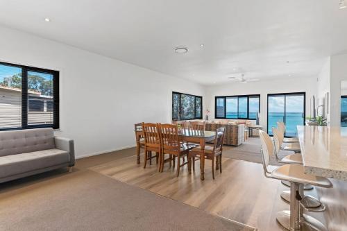 a dining room and living room with a table and chairs at Breath taking Bay Views Private Pad Spacious in Morisset East