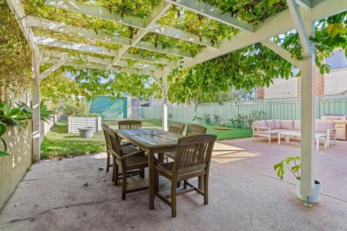 a patio with a table and chairs under a pergola at Catalina Bay - Child & Pet Friendly in Rathmines